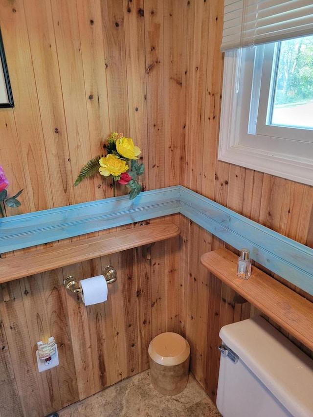 bathroom with wood walls and toilet