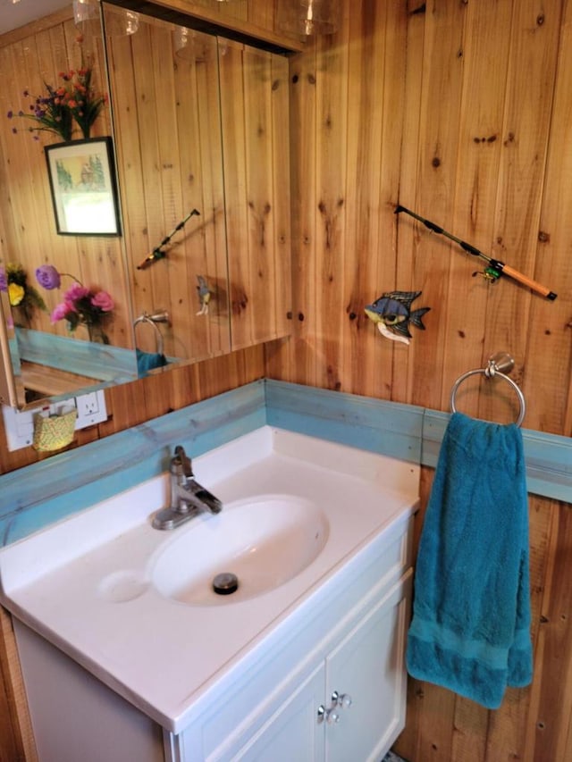 bathroom featuring wooden walls and vanity