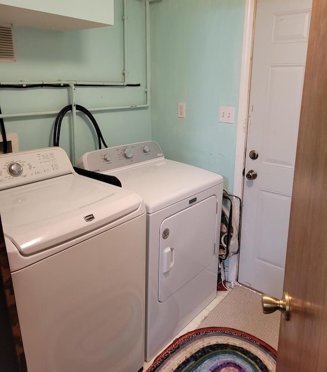 laundry room featuring separate washer and dryer and tile patterned flooring