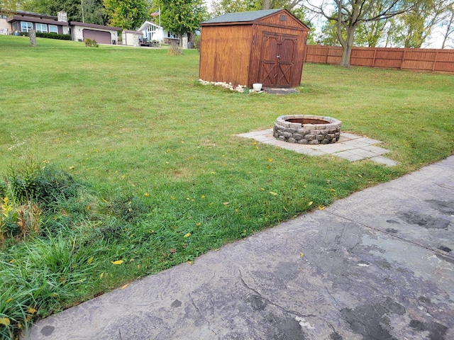 view of yard with a shed and an outdoor fire pit