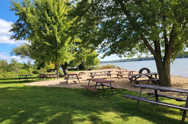 view of property's community featuring a lawn and a water view