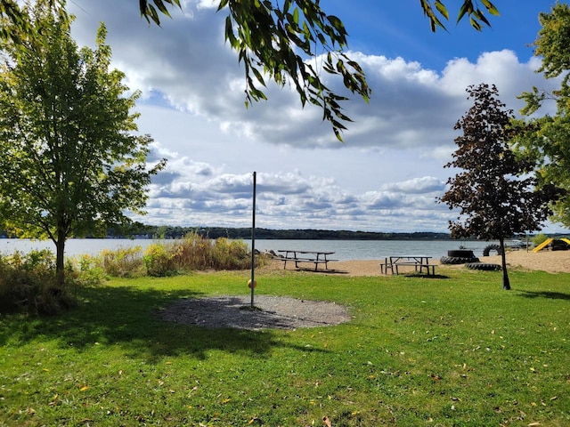 view of property's community with a lawn and a water view