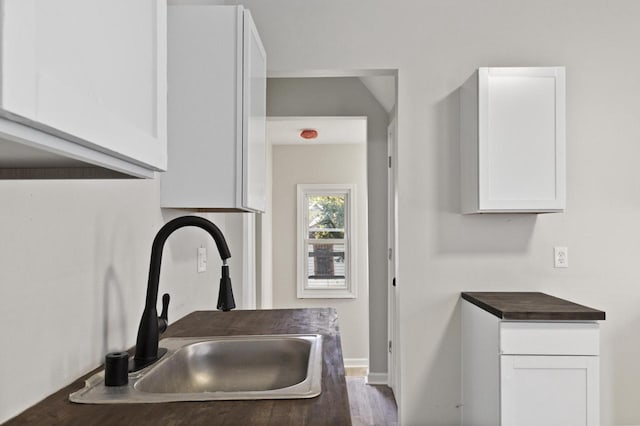 kitchen featuring white cabinetry, sink, and dark hardwood / wood-style flooring