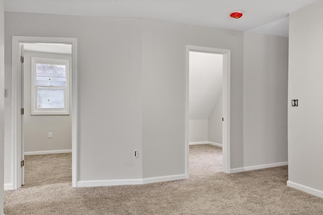 empty room featuring light carpet and vaulted ceiling