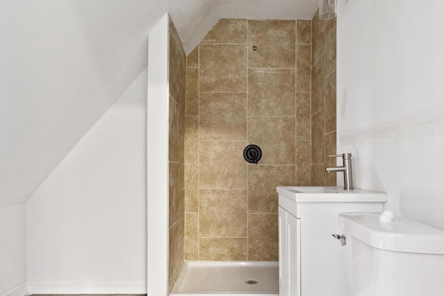 bathroom with lofted ceiling, toilet, and tiled shower