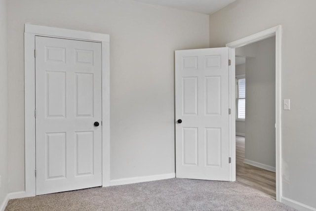 unfurnished bedroom featuring light carpet and a closet