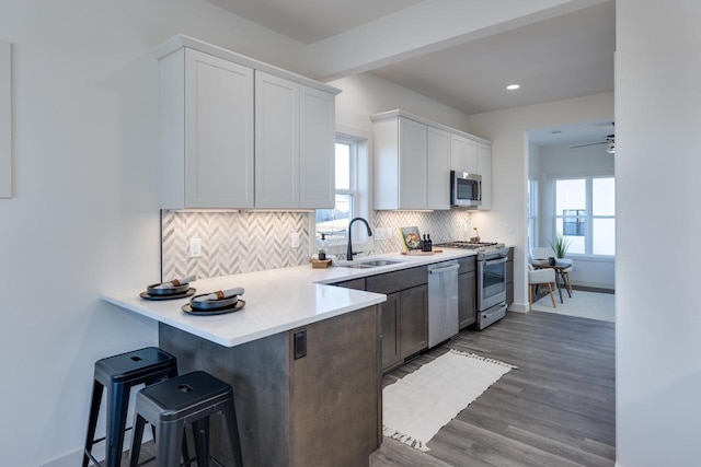 1295 Stonehaven Dr, Sun Prairie, WI 53590 - kitchen with a sink, a wealth of natural light, a breakfast bar area, and stainless steel appliances