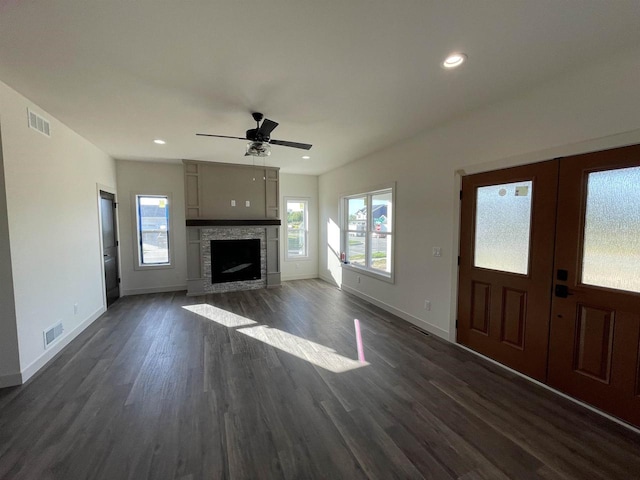 unfurnished living room with a fireplace, dark hardwood / wood-style flooring, and ceiling fan