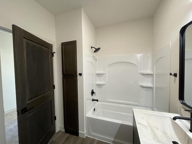 bathroom featuring wood-type flooring, vanity, and bathing tub / shower combination