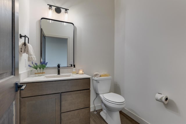 bathroom with vanity, toilet, and wood-type flooring