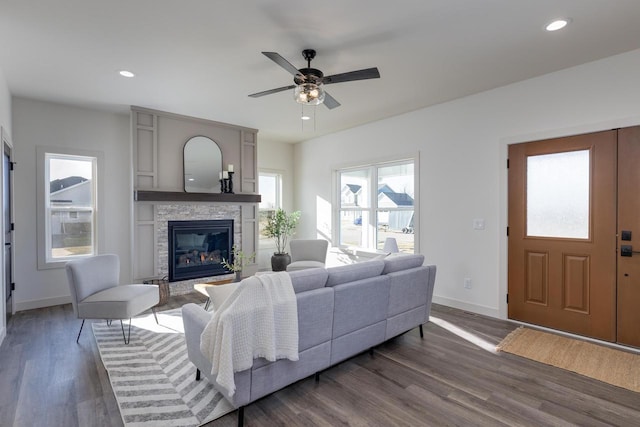 1295 Stonehaven Dr, Sun Prairie, WI 53590 - living room with a stone fireplace, ceiling fan, baseboards, and dark wood-style floors