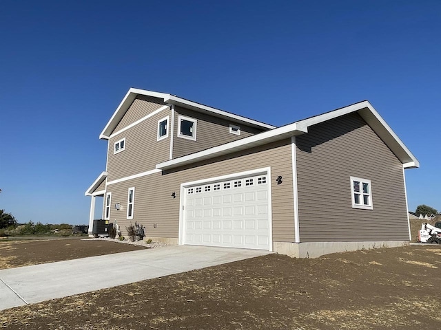 view of side of property featuring cooling unit and a garage