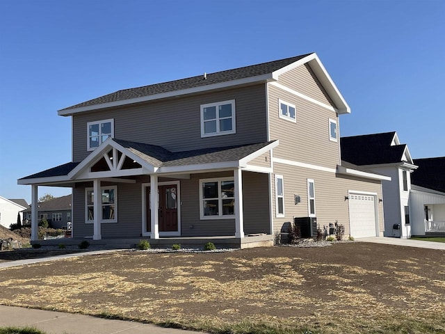 view of front of property with covered porch, central AC unit, and a garage