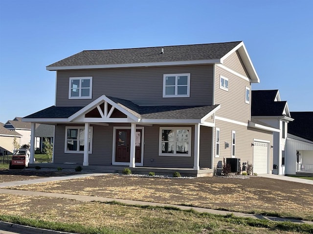 view of front of house featuring central AC unit, a garage, and a porch