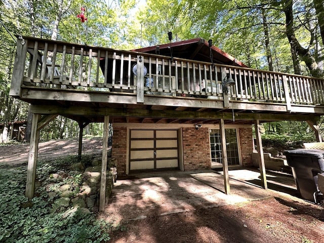 rear view of property with a garage and a deck