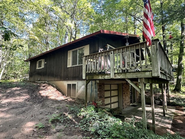 rear view of property featuring a wooden deck