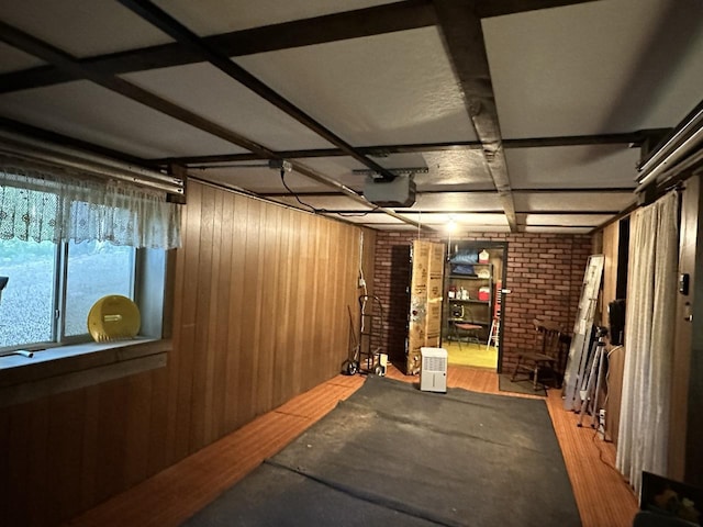 interior space with wood walls, brick wall, and hardwood / wood-style flooring