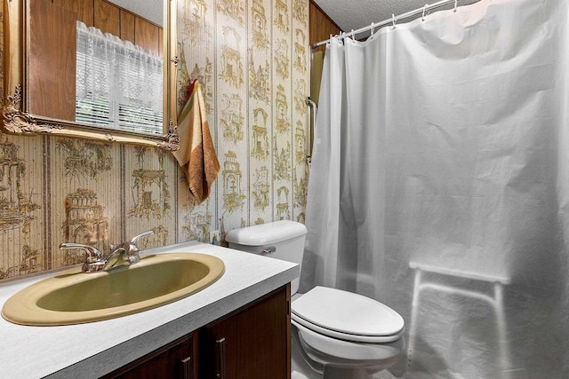 bathroom with a shower with curtain, vanity, toilet, and a textured ceiling