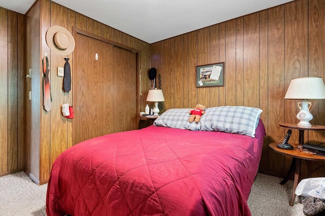 carpeted bedroom featuring wooden walls