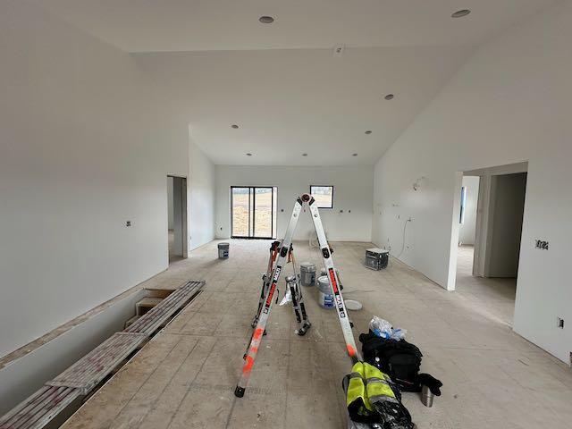 unfurnished room featuring high vaulted ceiling