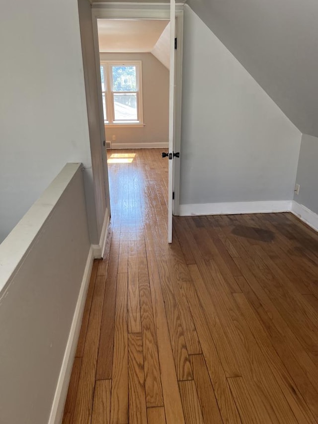 hallway featuring wood-type flooring and lofted ceiling