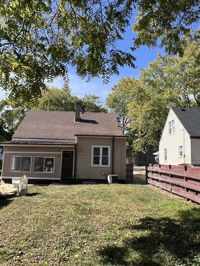 back of house with a lawn and central air condition unit