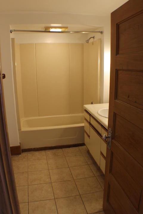 bathroom with vanity, tile patterned flooring, and shower / washtub combination