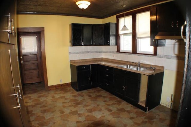 kitchen featuring backsplash, sink, extractor fan, and decorative light fixtures