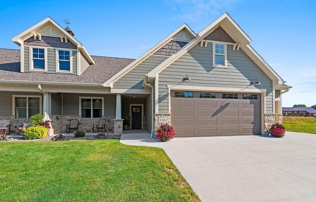 craftsman house featuring a garage, covered porch, and a front yard