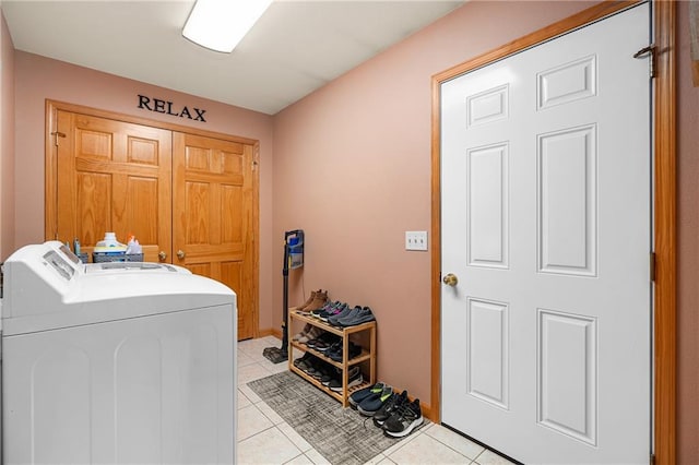 clothes washing area with washer and clothes dryer and light tile patterned floors