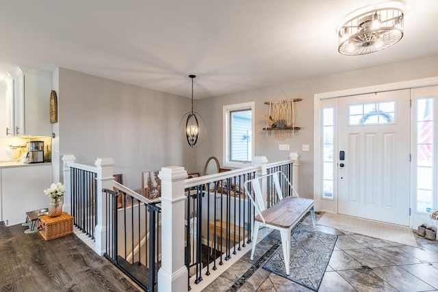 foyer with dark wood-type flooring and a chandelier