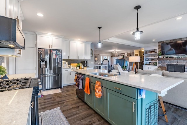 kitchen featuring appliances with stainless steel finishes, a kitchen island with sink, white cabinetry, and sink