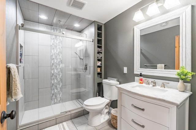 bathroom with tile patterned flooring, walk in shower, vanity, and toilet