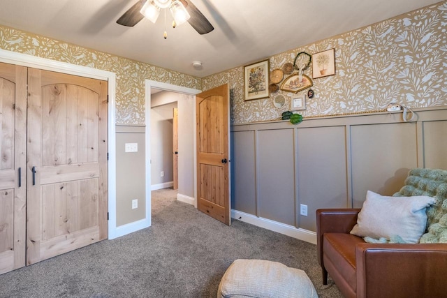 sitting room with ceiling fan and carpet flooring