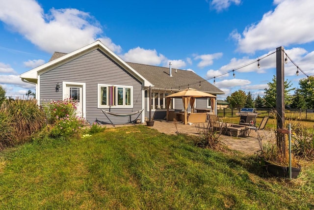 rear view of house with a gazebo, a lawn, and a patio