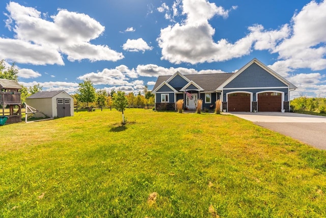 view of front of home with a garage, a front lawn, and a shed