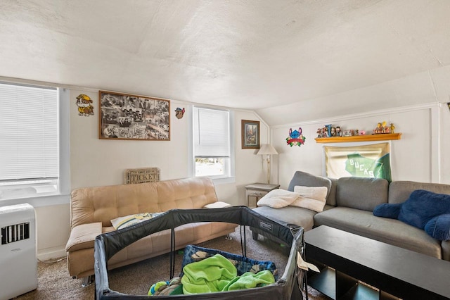 carpeted living room with a textured ceiling, heating unit, and vaulted ceiling