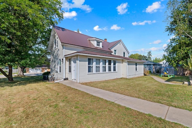 view of front of house featuring a trampoline and a front lawn