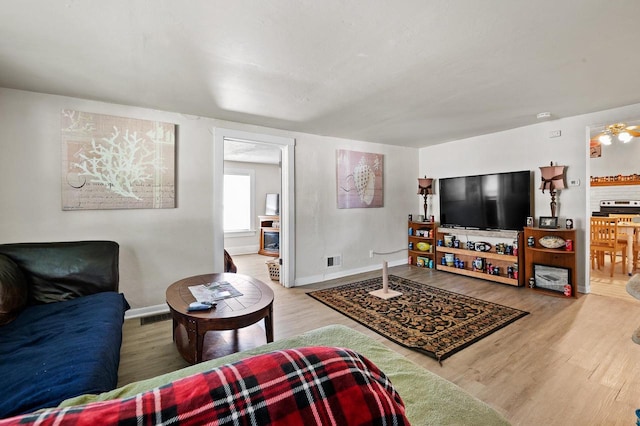 living room featuring ceiling fan and hardwood / wood-style floors