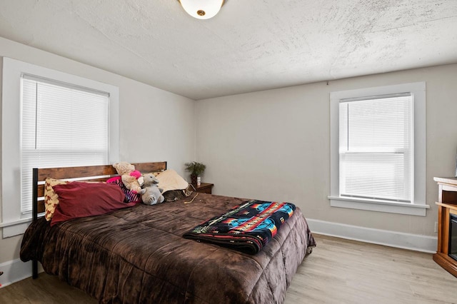 bedroom featuring light wood-type flooring and a textured ceiling