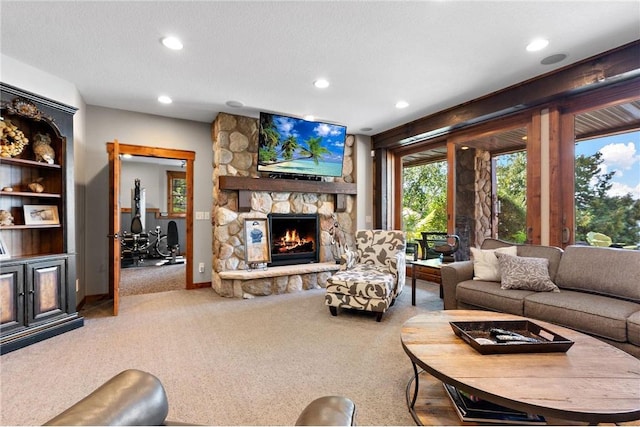 living room with a stone fireplace, a textured ceiling, and carpet flooring