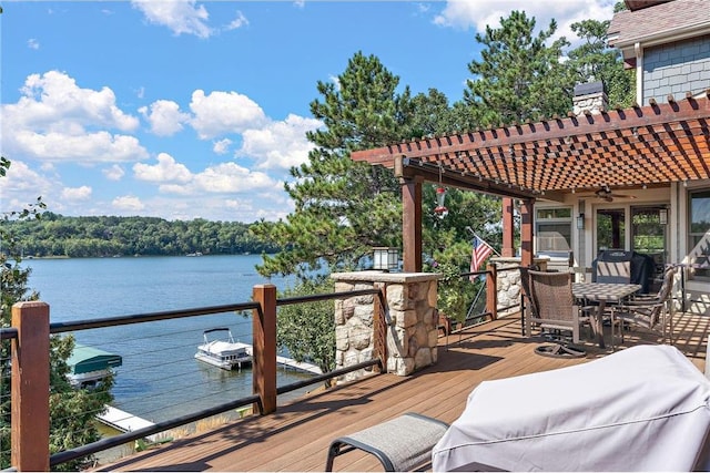 deck with ceiling fan, a pergola, and a water view