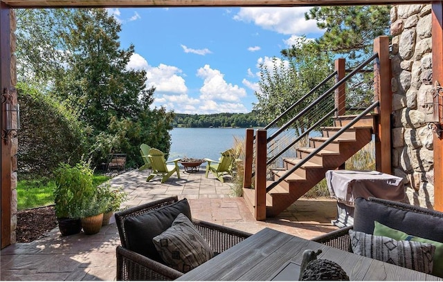 view of patio featuring a water view and a fire pit