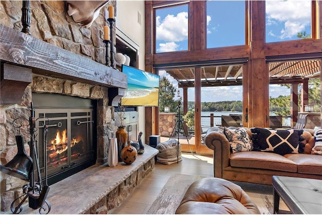 living room featuring a healthy amount of sunlight, a high ceiling, and a fireplace