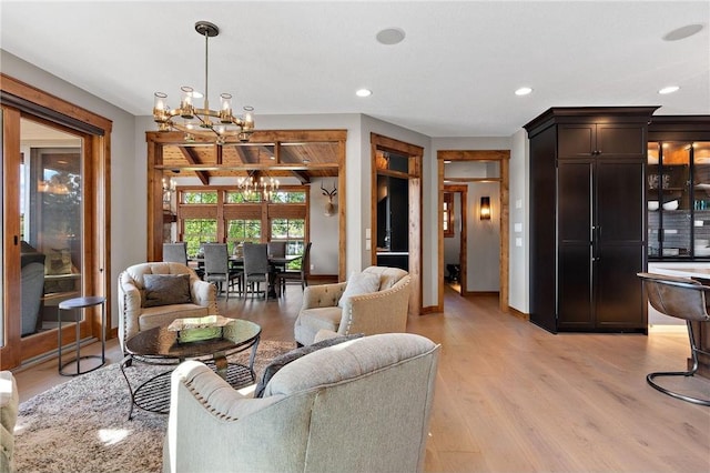 living room with an inviting chandelier and light hardwood / wood-style floors