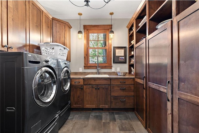 clothes washing area featuring cabinets, dark hardwood / wood-style flooring, washer and dryer, and sink