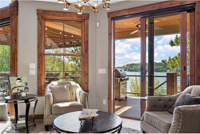 living room with a water view, hardwood / wood-style floors, a chandelier, and a healthy amount of sunlight