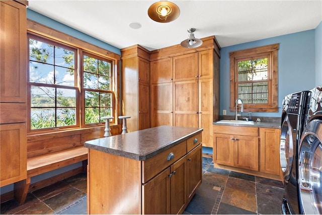 interior space with sink, washing machine and clothes dryer, and a center island