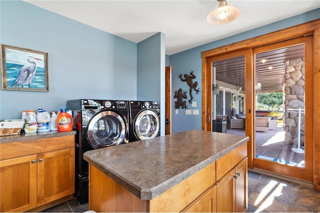 washroom featuring washing machine and clothes dryer and cabinets