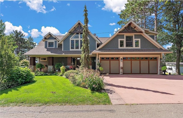 craftsman-style house featuring a garage, a front lawn, and covered porch